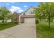 Traditional home with a brick and vinyl facade, featuring a two-car garage and well-kept front lawn at 14542 Baldwin Ln, Carmel, IN 46032