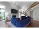 Spacious living room featuring a blue sectional, fireplace, wood floors, and vaulted ceilings at 14542 Baldwin Ln, Carmel, IN 46032