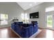 Bright living room with wood floors, vaulted ceilings, a fireplace, and a striking blue sectional sofa at 14542 Baldwin Ln, Carmel, IN 46032