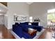 Comfortable living room with a plush blue sectional sofa, wood floors, and view to the kitchen at 14542 Baldwin Ln, Carmel, IN 46032