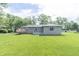 Expansive backyard with green grass, mature trees, and a view of the back of the home at 156 N Eastern Village Dr, Greenfield, IN 46140