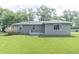 Lush backyard featuring a green lawn, back deck, and siding in light-green at 156 N Eastern Village Dr, Greenfield, IN 46140