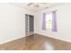 Bright bedroom with wood-look floors, closet shelving, and a sunlit window with lavender curtains at 156 N Eastern Village Dr, Greenfield, IN 46140