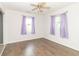 A bright bedroom with dark wood flooring, ceiling fan, and natural light through two windows at 156 N Eastern Village Dr, Greenfield, IN 46140