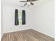 A bright bedroom with a ceiling fan, dark curtains, and laminate wood flooring at 156 N Eastern Village Dr, Greenfield, IN 46140