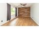 Modern living room featuring wood-look tile flooring, wood accent wall, and natural light from a large window at 156 N Eastern Village Dr, Greenfield, IN 46140