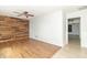 Bright, open living room featuring wood-look tile floors, a unique wood accent wall, and a ceiling fan at 156 N Eastern Village Dr, Greenfield, IN 46140