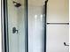 Modern bathroom featuring a shower with glass doors, black fixtures, and marble wall tiles at 1718 Thaddeus St, Indianapolis, IN 46203