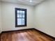 Cozy bedroom with hardwood floors, and natural light streaming through the window at 1718 Thaddeus St, Indianapolis, IN 46203