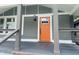 Inviting front porch with gray railings, an orange front door, and stylish lighting fixtures at 1718 Thaddeus St, Indianapolis, IN 46203