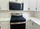 An updated stainless steel oven and cooktop are accented by white cabinets with white countertops at 1718 Thaddeus St, Indianapolis, IN 46203