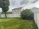 Spacious backyard of the property features a green lawn, a privacy fence and mature trees for shade at 1774 Blue Grass Pkwy, Greenwood, IN 46143