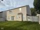 Spacious backyard of the property features a green lawn, privacy fence, and view of the home's exterior at 1774 Blue Grass Pkwy, Greenwood, IN 46143