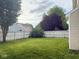Backyard featuring a spacious lawn and white privacy fence, enhanced by mature trees and manicured shrubs at 1774 Blue Grass Pkwy, Greenwood, IN 46143
