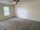 This carpeted bedroom has a ceiling fan and a window at 1774 Blue Grass Pkwy, Greenwood, IN 46143