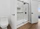Clean bathroom featuring a glass enclosed tile shower, toilet, and wood look flooring at 1837 S East St, Indianapolis, IN 46225
