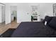 Modern bedroom with wood floors, ensuite bathroom, and view into the kitchen and living space at 1837 S East St, Indianapolis, IN 46225