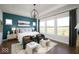 Inviting bedroom featuring a teal accent wall, large windows, hardwood floors, and a cozy seating area at 19848 Chatsworth Blvd, Westfield, IN 46074