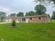 Charming single-story home with brick and tan siding, a well-maintained lawn, and a separate garage in the back at 2026 S Q St, Elwood, IN 46036