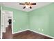 Cozy bedroom with hardwood floors and ceiling fan offering view into modern kitchen at 2201 Schoolmarm Dr, Greenfield, IN 46140