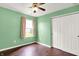 This bedroom features hardwood floors, a ceiling fan, and a large closet at 2201 Schoolmarm Dr, Greenfield, IN 46140