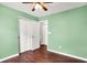 Brightly colored bedroom featuring hardwood floors, ceiling fan, and closet at 2201 Schoolmarm Dr, Greenfield, IN 46140