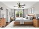 Cozy bedroom with a ceiling fan, wood furnishings, and large window offering a view of the outdoors at 2201 Schoolmarm Dr, Greenfield, IN 46140