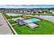 Aerial view of a community pool, spa, and playground nestled beside a pond for residents' enjoyment at 2201 Schoolmarm Dr, Greenfield, IN 46140