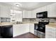 Modern kitchen featuring stainless steel appliances, white cabinets, hardwood floors, and a stylish tiled backsplash at 2201 Schoolmarm Dr, Greenfield, IN 46140