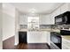Well-equipped kitchen with stainless steel appliances, white cabinets, stylish backsplash, and hardwood flooring at 2201 Schoolmarm Dr, Greenfield, IN 46140