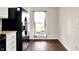 Bright kitchen nook with hardwood floors, featuring a window with views of the landscaped exterior and a modern refrigerator at 2201 Schoolmarm Dr, Greenfield, IN 46140