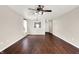 Large living room with dark wood floors, a ceiling fan, and access to the dining room at 2201 Schoolmarm Dr, Greenfield, IN 46140