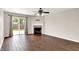 Bright living room with dark wood floors, a fireplace, ceiling fan, and sliding glass doors at 2201 Schoolmarm Dr, Greenfield, IN 46140