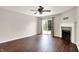 Large living room with dark wood floors, a fireplace, ceiling fan, and access to the backyard at 2201 Schoolmarm Dr, Greenfield, IN 46140