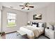 This bedroom features a ceiling fan, large window, and contemporary décor with a queen bed and neutral color palette at 2201 Schoolmarm Dr, Greenfield, IN 46140