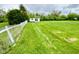 This backyard features a shed in a lush green lawn, complemented by a classic white picket fence at 2221 E 35Th St, Anderson, IN 46013