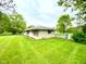 View of home's exterior with a stone facade and green lawn on a sunny day at 2221 E 35Th St, Anderson, IN 46013