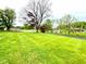 Expansive front yard with mature trees, offering serene views and curb appeal at 2221 E 35Th St, Anderson, IN 46013