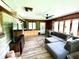 Comfortable living room with wood-paneled walls, large windows, and a spacious sectional sofa at 2221 E 35Th St, Anderson, IN 46013