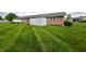 Brick home exterior featuring a white fence, green lawn, and well-maintained landscaping at 2508 Pamela Ct, Anderson, IN 46012