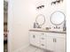 Elegant bathroom with dual sinks, white cabinets, and modern round mirrors at 2686 Lafayette Ave, Columbus, IN 47201