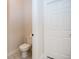 Neutral half bathroom featuring a modern toilet and dark fixtures, with a white door and molding at 2686 Lafayette Ave, Columbus, IN 47201