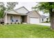 Inviting front of home with lush green lawn and covered porch with chairs at 2686 Lafayette Ave, Columbus, IN 47201