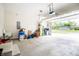 Spacious garage with open door, lawn care items and concrete floors at 2686 Lafayette Ave, Columbus, IN 47201