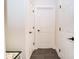Neutral hallway featuring 3 white doors, neutral walls and dark tile flooring at 2686 Lafayette Ave, Columbus, IN 47201
