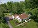 Areal view of a home surrounded by lush trees, features a detached garage, and green lawn at 2929 E 62Nd St, Indianapolis, IN 46220