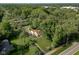 Areal view of a white house with a brown roof surrounded by lush greenery and tall trees at 2929 E 62Nd St, Indianapolis, IN 46220