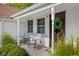 Welcoming front porch featuring chairs, side table, and front door adorned with a wreath at 2929 E 62Nd St, Indianapolis, IN 46220