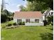 Charming house boasts red shutters, a well-manicured lawn, and a quaint white fence at 2929 E 62Nd St, Indianapolis, IN 46220