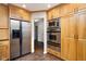 Well-lit kitchen featuring stainless steel refrigerator and oven, and beautiful wood cabinetry, offering ample storage at 2929 E 62Nd St, Indianapolis, IN 46220